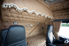 Braune LKW-Innenraumbord�re im Alkantara-Stil mit wei�er Quastenborte, �ber dem oberen Bett.
