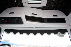 Schwarze Scheibenbord�re mit heller Kunstlederkante und Wellenform im LKW-Fahrerhaus.