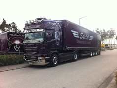 Dunkelvioletter Scania LKW mit gl�nzendem Scheibengitter und Anh�nger.