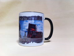 Wei�e Tasse mit schwarzem Henkel und Rand, bedruckt mit einem dunklen LKW und den Texten "THE NEW WARRIOR" und "TRUCKS STOP HERE".