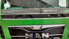 Silbernes Scheibengitter mit Wabenmuster auf der Front eines gr�nen MAN LKWs.