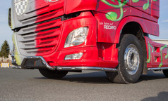 Chromfarbene Eckrohre mit integrierten LEDs am unteren Bereich eines roten DAF LKW.