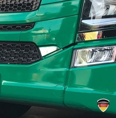 Spiegelpolierte Edelstahl Blende 2 an der Front eines gr�nen Scania LKW.