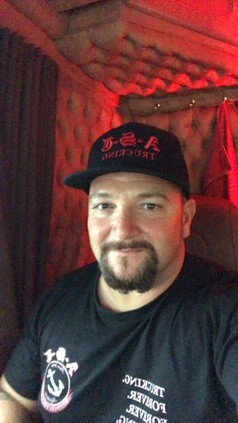 Mann tr�gt schwarze Flexfit Cap mit rotem D-S-A TRUCKING Logo.