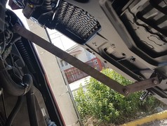 Grauer Distanzhalter aus Metall, im K�hlergrillbereich eines LKW montiert, sichert die GFK Scheibenblende.