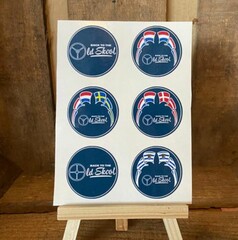 Runde, blaue Old Skool Aufkleber mit Lenkrad-Symbolen und skandinavischen Flaggen auf einem St�nder.