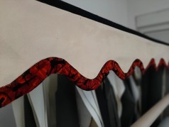 Scheibenbord�re in Lederoptik, hell, mit roter, gemusterter Pl�schkante. Zeigt doppelt gen�hten Stoff.