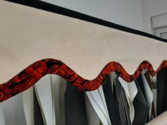 Beige Scheibenbord�re aus Wildlederimitat mit schwarzem Klettband und gewellter rot-schwarz gemusterter Pl�schkante.