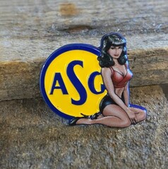 Farbenfrohe ASG Pin Up Anstecknadel mit gelbem Kreis, blauer ASG-Schrift und einer Pin-up-Frau in Rot und Schwarz.
