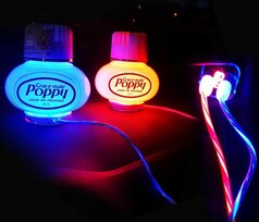 Beleuchtete Poppy Lufterfrischer mit roten und blauen LED-Lichtplatten und leuchtenden USB-Kabeln.