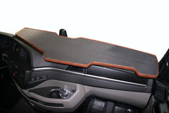 Gro�e LKW-Armaturenbrett-Ablage in Carbon-Optik mit braunem Holzrand.