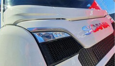 Wei�e Scheibenblende auf einem Scania LKW. Frontansicht mit Scania Logo und Scheinwerfern.