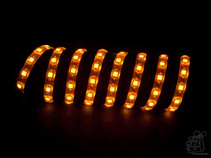 Orange leuchtender LED-Streifen, spiralf�rmig auf dunklem Hintergrund.