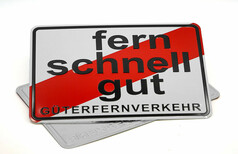 Wei�es Schild mit diagonalem roten Streifen und schwarzem Text "fern schnell gut" und "G�TERFERNVERKEHR".