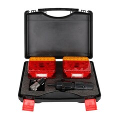 Offener schwarzer Koffer mit kabellosem LED-Lampenset: zwei rote und gelbe Leuchten und Stecker auf Schaumstoff.