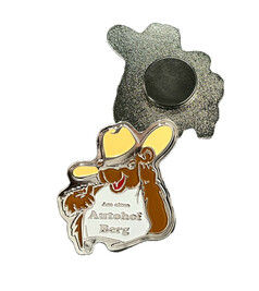 Metallmagnet in Form eines braunen Cartoon-B�ren mit gelbem Cowboyhut. Auf dem wei�en Shirt steht 