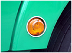Edelstahl-Blinkereinrahmung am gr�nen Kotfl�gel eines LKW mit orangefarbenem Blinker.