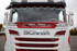 Rotes und wei�es Scheibengitter mit Wabenmuster an der Front eines wei�en Scania LKW.