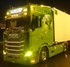 Beleuchtetes Transparent-Leuchtschild "MOLLER" auf einem gr�nen Scania New Generation LKW bei Nacht.