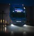 Blauer Scania LKW mit leuchtendem Ledson Flexistrip Arc LED-Streifen in Xenon-Wei� am K�hlergrill, nachts auf nassem Asphalt.